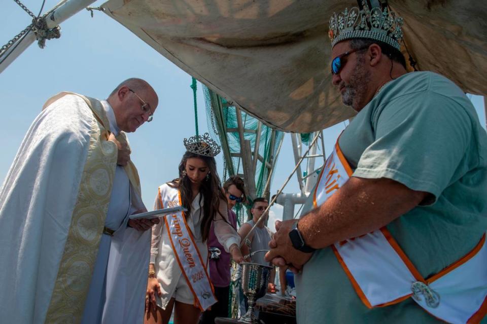 Msgr. Dominick Fullam, pastor at St. Michael’s Catholic Church, leads the blessing with the Shrimp King and Queen during the Blessing of the Fleet in Biloxi on Sunday, May 28, 2023.