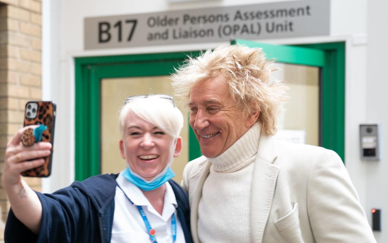 Rod Stewart takes a selfie with a member of staff at Princess Alexandra Hospital in Essex - Joe Giddens/PA