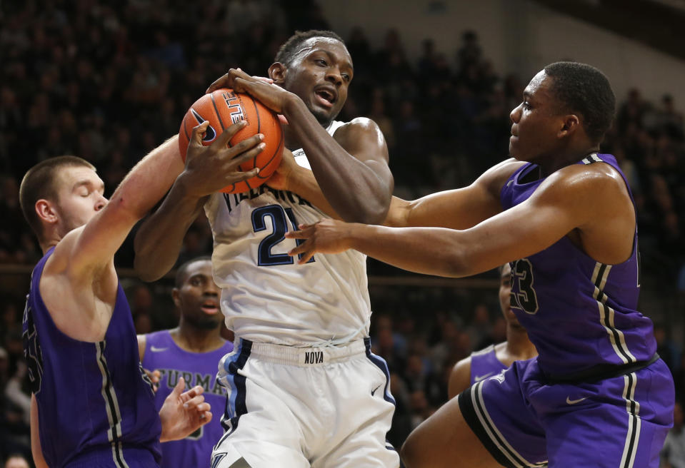 Villanova forward Dhamir Cosby-Roundtree (21) and Furman forward Matt Rafferty (32) and guard Jordan Lyons (23) fight for a rebound during the second half of an NCAA college basketball game, Saturday, Nov. 17, 2018, in Villanova, Pa. Furman won 76-68 in overtime. (AP Photo/Laurence Kesterson)