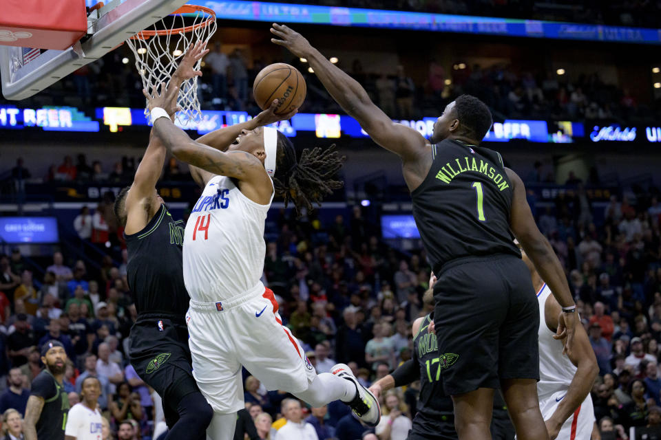 New Orleans Pelicans forward Zion Williamson (1) goes up to swat the ball away from Los Angeles Clippers guard Terance Mann (14) during the first half of an NBA basketball game in New Orleans, Friday, March 15, 2024. (AP Photo/Matthew Hinton)