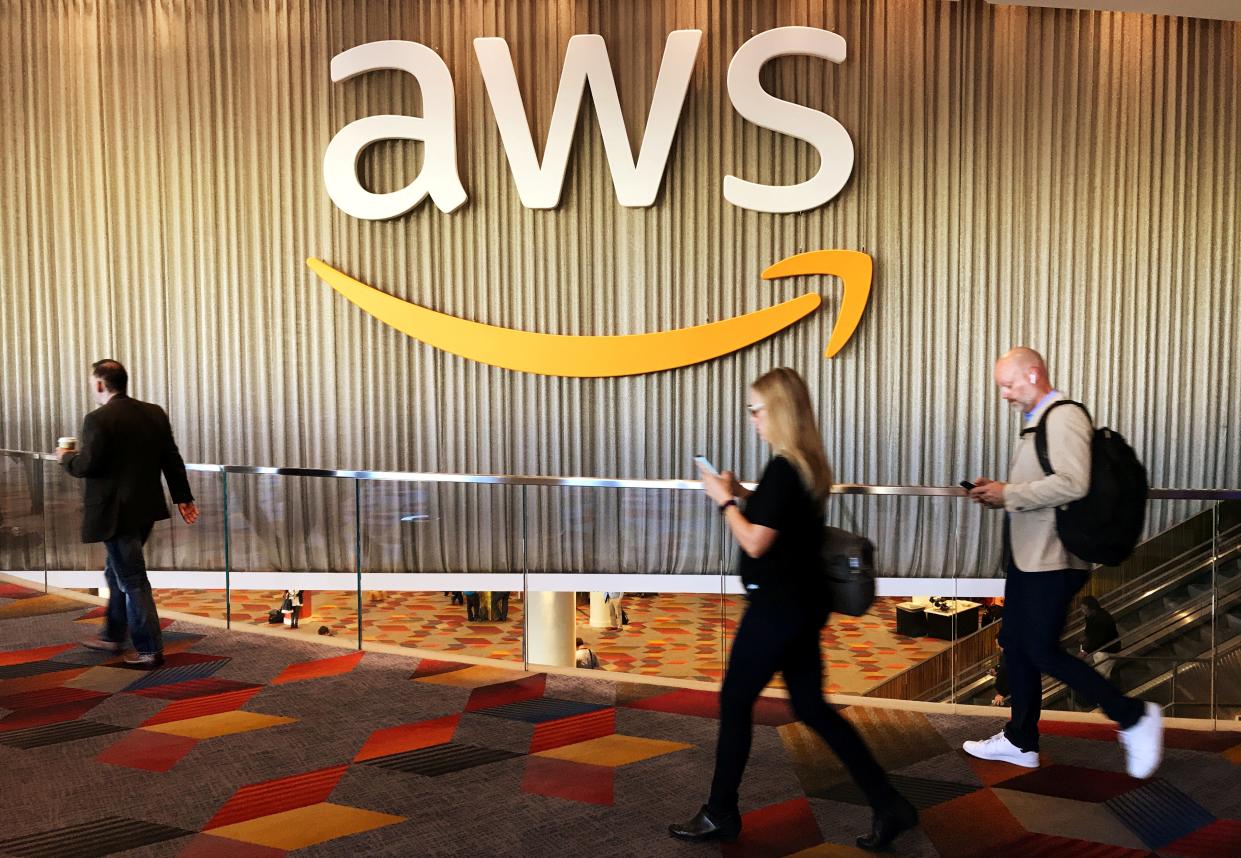 FILE PHOTO: Attendees at Amazon.com Inc annual cloud computing conference walk past the Amazon Web Services logo in Las Vegas, Nevada, U.S., November 30, 2017. REUTERS/Salvador Rodriguez/File Photo