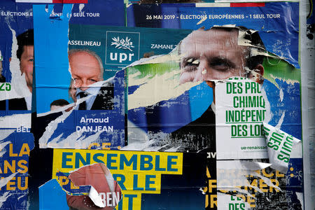 Torn and overlapping official posters of candidates for the 2019 European parliament elections including a poster of French President Emmanuel Macron as the cover for the Renaissance (Renewal) list, are seen in Cambrai, France, May 27, 2019. REUTERS/Pascal Rossignol