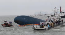 South Korean Coast Guard officers search for missing passengers aboard a sunken ferry in the water off the southern coast near Jindo, South Korea, Thursday, April 17, 2014. Strong currents, rain and bad visibility hampered an increasingly anxious search Thursday for more than 280 passengers still missing a day after their ferry flipped onto its side and sank in cold waters off the southern coast of South Korea. (AP Photo/Ahn Young-joon)