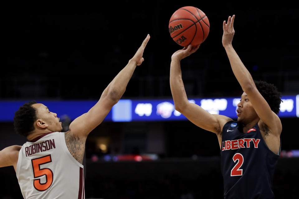 Liberty guard Darius McGhee, right, shoots over Virginia Tech guard Justin Robinson during the second half of a second-round game in the NCAA men's college basketball tournament Sunday, March 24, 2019, in San Jose, Calif. (AP Photo/Ben Margot)