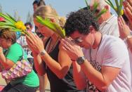 This handout picture taken by BEC Tero on December 30, 2011 shows women's world tennis number one Caroline Wozniacki of Denmark (L) and men's world number three golfer Rory McIlroy (R) of Northern Ireland praying at the buddhist temple in Hua Hin resort. Wozniacki has arrived in Thailand for a charity tennis match against Victoria Azarenka to raise money for the country's recent flood crisis, a spokeswoman said December 30. (Photo by Ho/bec Tero/AFP/Getty Images)