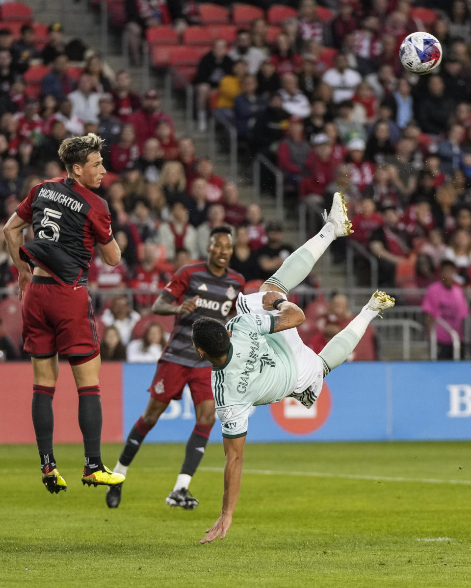 Atlanta United forward Giorgos Giakoumakis (7) falls to the ground after battling for the ball against Toronto FC defender Lukas MacNaughton (5) during the first half of an MLS soccer match Saturday, April 15, 2023, in Toronto. (Andrew Lahodynskyj/The Canadian Press via AP)