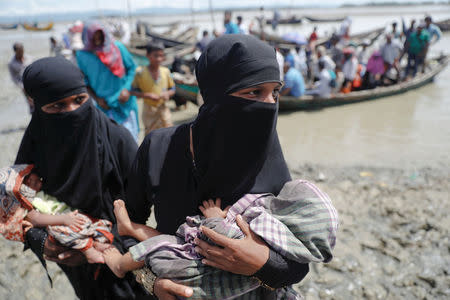 Rohingya refugees who just arrived from Myanmar carry their newborn babies as they make their way to a relief centre in Teknaf, near Cox's Bazar in Bangladesh, October 3, 2017. REUTERS/Damir Sagolj