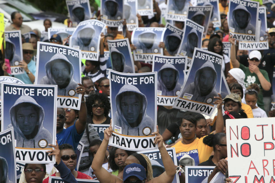 FILE - Protesters hold signs during a march and rally for slain Florida teenager Trayvon Martin on March 31, 2012, in Sanford, Fla. The small city north of Orlando had a history of racial tensions even before Martin's killing. When local police didn't charge Zimmerman right away, thousands of protesters filled the streets. (AP Photo/Julie Fletcher, File)