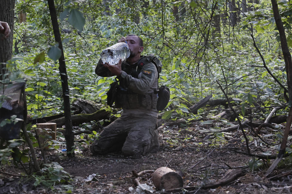 A Ukrainian soldier drinks water on the frontline near Kreminna, Luhansk region, Ukraine, Thursday, June 8, 2023. (Roman Chop via AP)