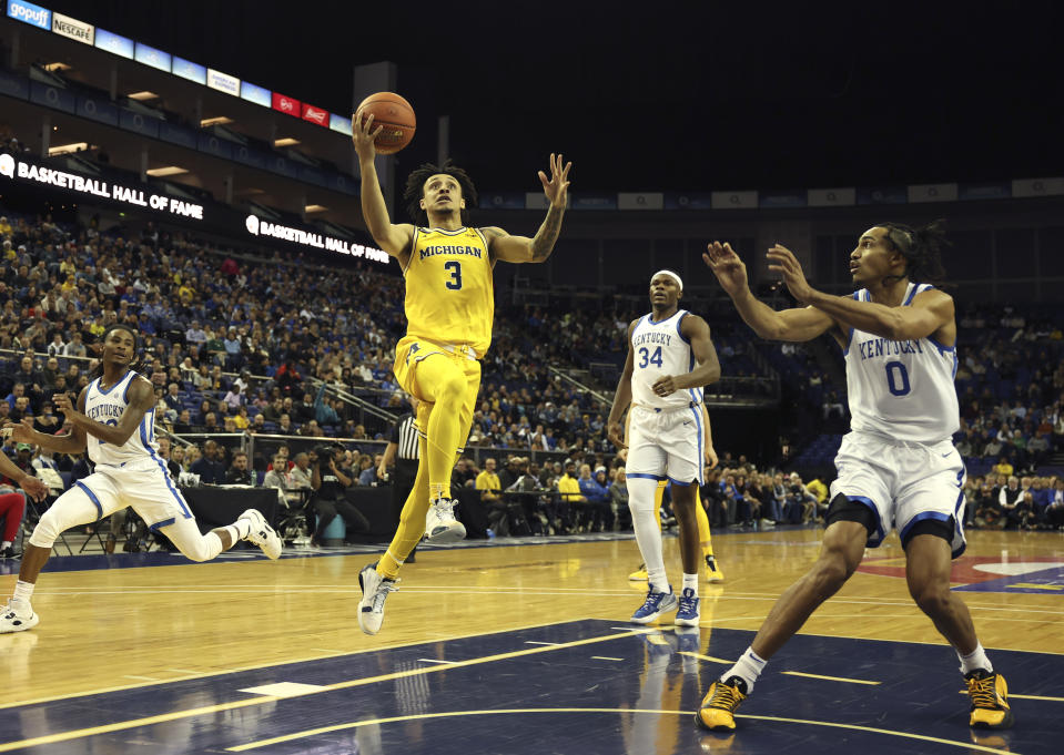 Michigan Wolverines' Jaelin Llewellyn (3) goes for the basket as Kentucky Wildcats' Jacob Toppin (0) defends during an NCAA basketball game between Michigan Wolverines and Kentucky Wildcats at the O2 Arena, in London, Sunday, Dec.4, 2022. (AP Photo/Ian Walton)