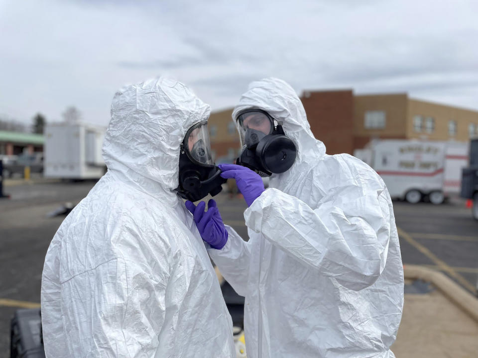 This photo provided by the Ohio National Guard, ONG 52nd Civil Support Team members prepare to enter an incident area to assess remaining hazards with a lightweight inflatable decontamination system (LIDS) in East Palestine, Ohio, Tuesday, Feb. 7, 2023. Authorities say air monitoring hasn’t detected dangerous levels of fumes in communities where crews released and burned toxic chemicals from a derailed train. But they said Tuesday that Ohio and Pennsylvania residents living close to the wreckage still aren’t being allowed in their homes.(Ohio National Guard via AP)