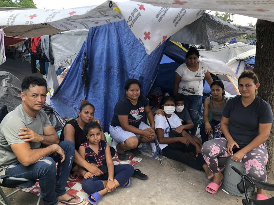 Neighbors at the Reynosa migrant camp include Honduran Lesly Pineda, far right, and Guatemalan Jose Torres, far left.