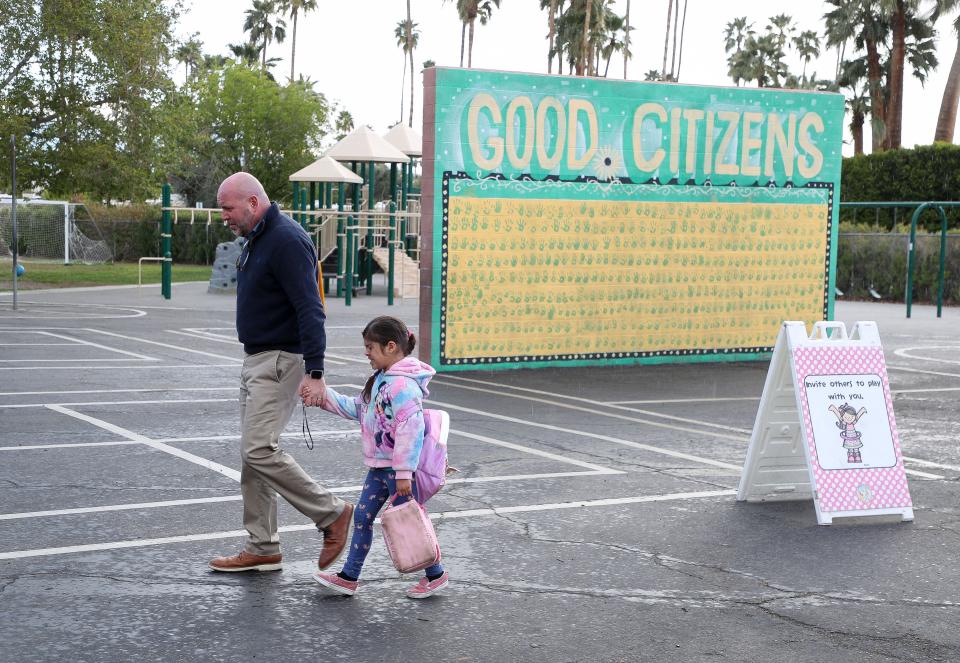 Cahuilla Elementary School principal Dr. Ryan Saunders comforts a young student who was having a difficult morning in Palm Springs, Calif., March 30, 2023. 