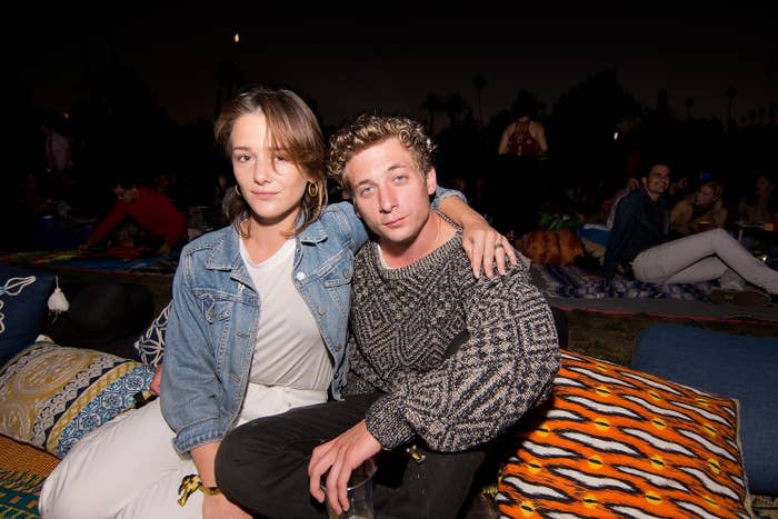 Closeup of Addison Timlin with her arm around Jeremy Allen White as they sit on a couch at an event
