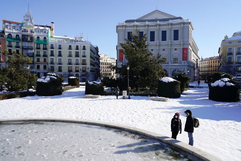 Dos personas en la plaza Oriente de Madrid