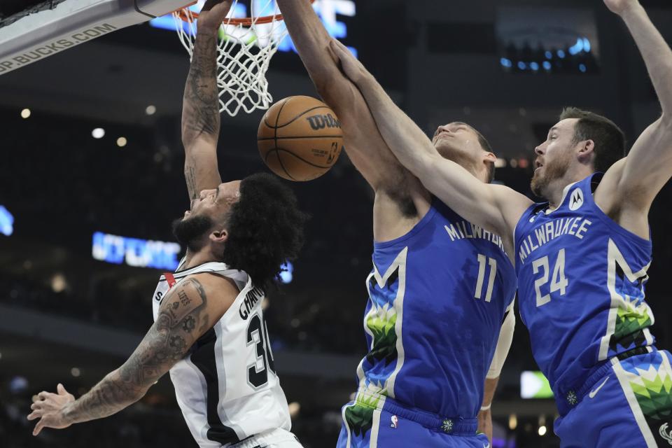 San Antonio Spurs' Julian Champagnie has a shot blocked by Milwaukee Bucks' Brook Lopez and Pat Connaughton during the first half of an NBA basketball game Wednesday, March 22, 2023, in Milwaukee. (AP Photo/Morry Gash)
