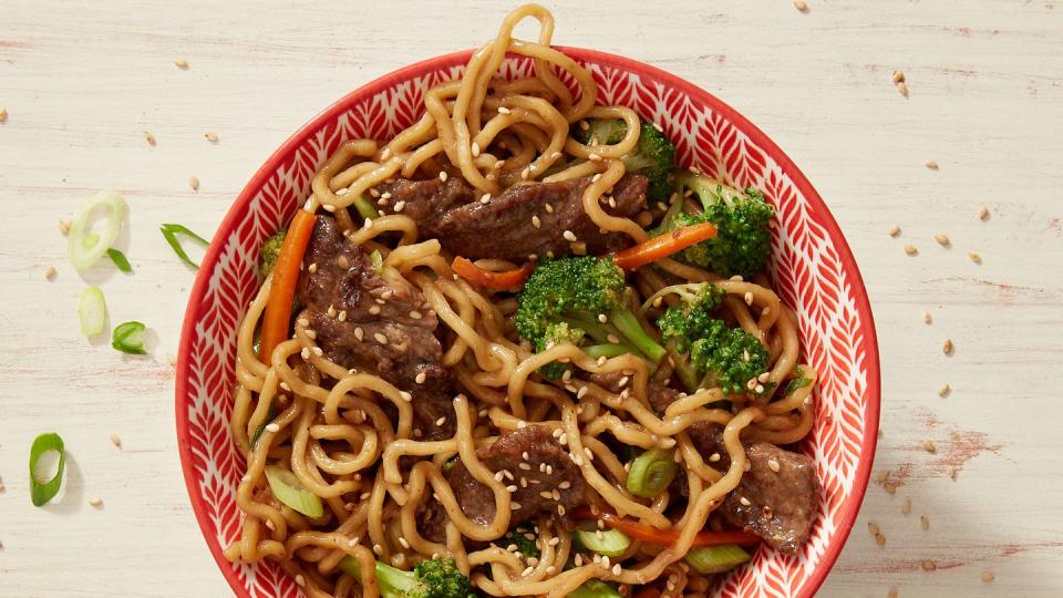 a big bowl of ramen noodles topped with juicy meatballs and broccoli