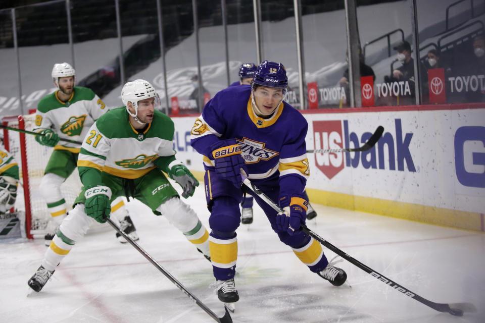 Los Angeles Kings center Trevor Moore (12) skates with the puck in front of Minnesota Wild defenseman Carson Soucy (21) in the first period during an NHL hockey game, Saturday, Feb. 27, 2021, in St. Paul, Minn. (AP Photo/Andy Clayton-King)