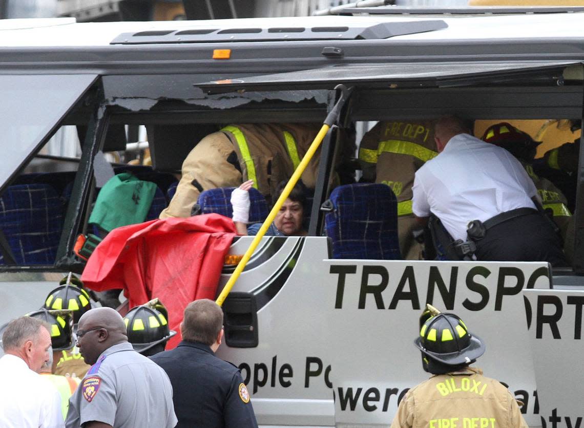 A charter bus passenger sat as rescue personnel worked around her after the bus was hit by a CSX train at the Main Street crossing on March 7, 2017, in Biloxi, Mississippi.