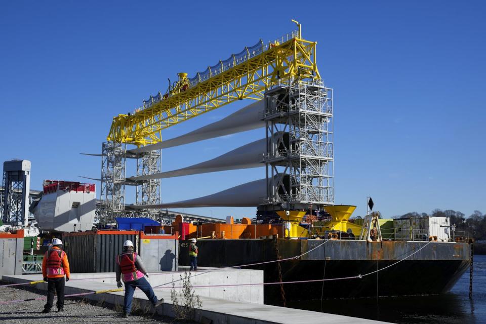 A ship carrying three gigantic blades stacked on top of each other.