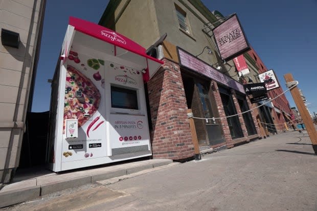 A slice of life during the pandemic: Senate Tavern's automated pizza vending machine in the ByWard Market, just outside the shuttered sports bar. This machine and another one in Old Ottawa South each dispense as many as 60 hot pizzas a day. (Francis Ferland/CBC - image credit)