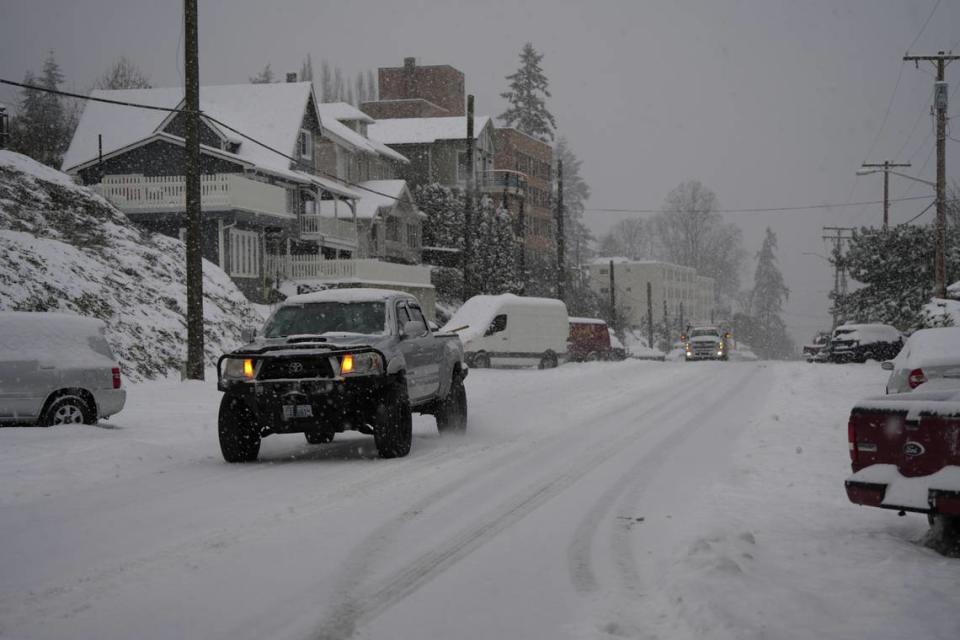 Vehicles drive through snow along N State Street on January 17, 2024, in Bellingham, Wash.