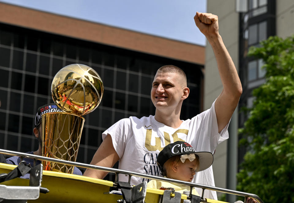 Nikola Jokić, with his daughter, celebrates the Denver Nuggets' NBA championship during a parade in downtown Denver on Thursday. (AAron Ontiveroz/The Denver Post)