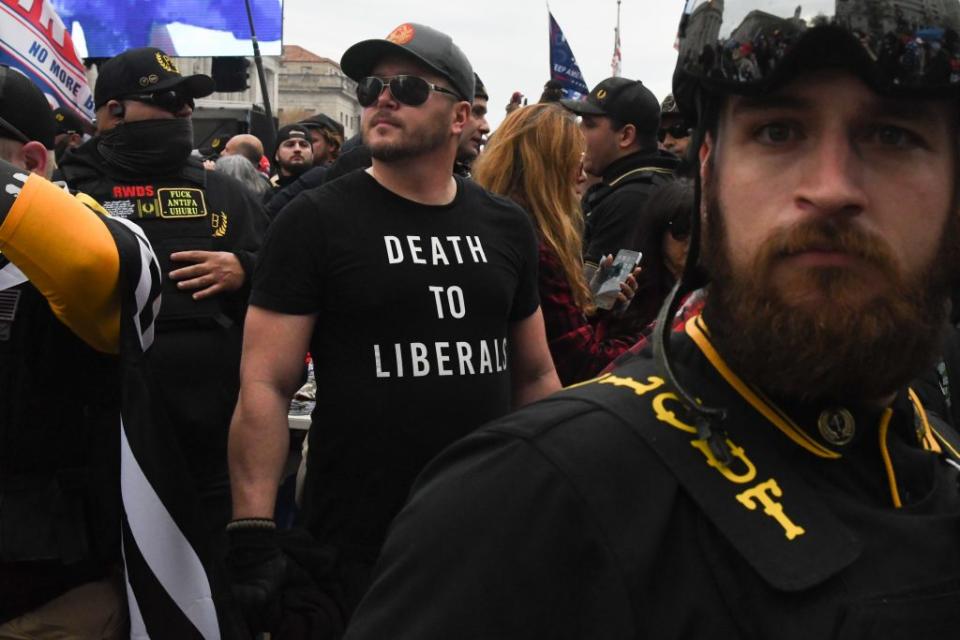 A member of the Proud Boys wearing a t-shirt that reads “death to liberals” stands with other Proud Boys in Freedom Plaza during a protest on December 12, 2020 in Washington, DC. (Photo by Stephanie Keith/Getty Images)