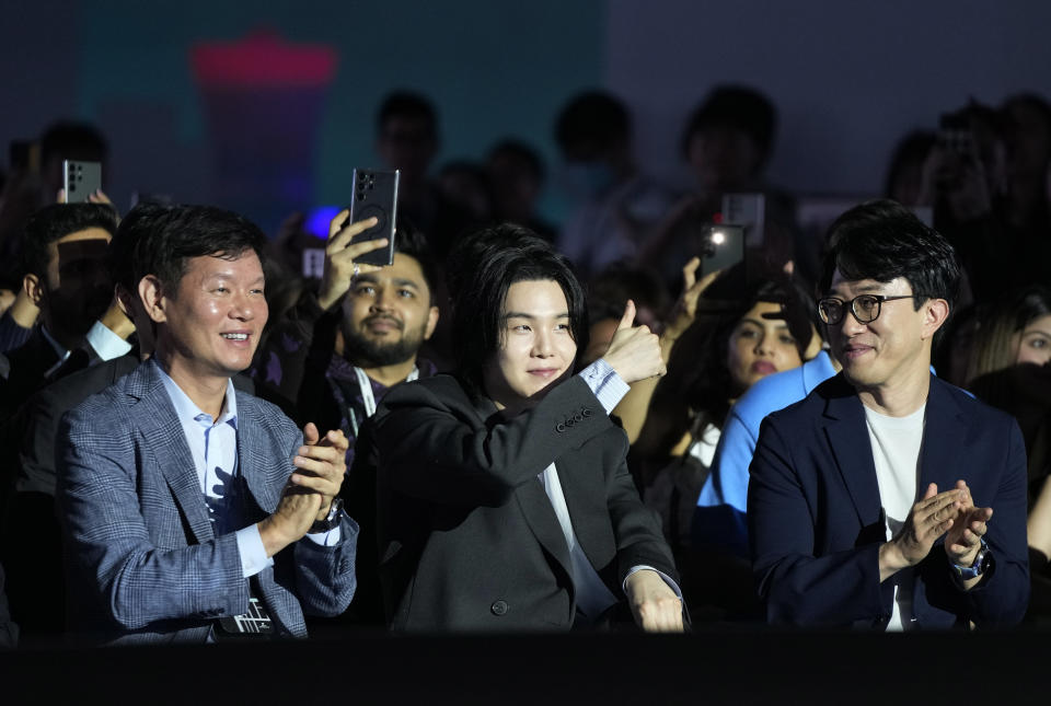 SUGA, center, a member of South Korean K-pop band BTS, gestures during the Galaxy Unpacked 2023 event at the COEX in Seoul, South Korea, Wednesday, July 26, 2023. Samsung Electronics on Wednesday unveiled two foldable smartphones as it continues to bet on devices with bending screens, a budding market that has yet to fully take off because of high prices. (AP Photo/Ahn Young-joon)