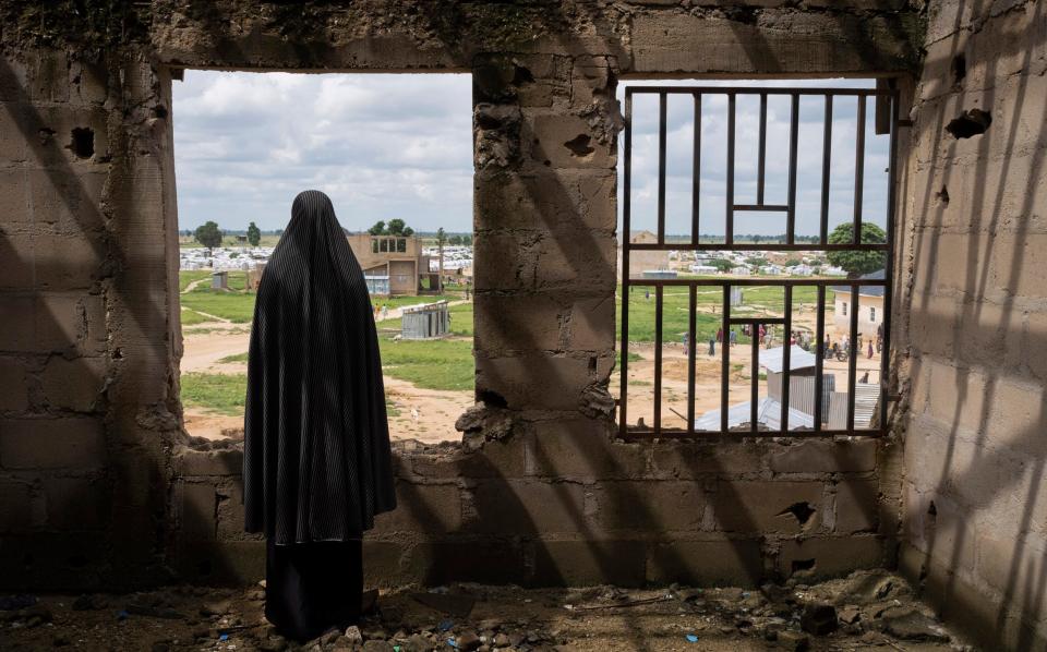 A woman who was kidnapped by Boko Haram and recruited as a bomber at an abandoned building at a camp for displaced people in Konduga, Nigeria - NYTNS / Redux / eyevine/LAURA BOUSHNAK 