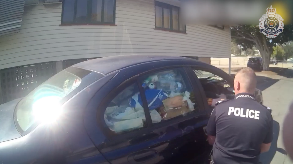 Plastic bottles and rubbish are seen filling up a side window of a car pulled over in Upper Mount Gravatt. The driver was pulled over because police said he couldn't see out his rear and side windows.