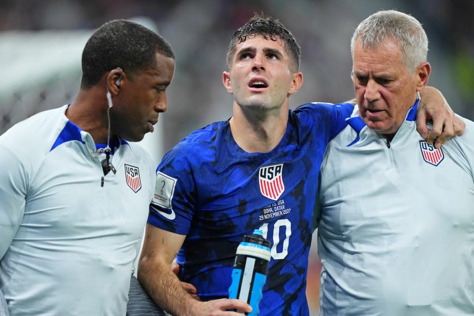 Christian Pulisic is helped to the sideline after colliding with Iran goalkeeper Alireza Beiranvand following his goal in the first half Tuesday.