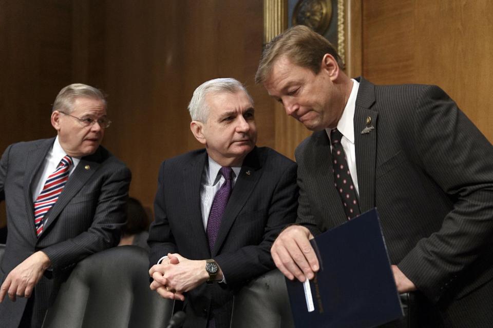 In this Feb. 27, 2014, file photo, Sen. Jack Reed, D-R.I., center, confers with Sen. Dean Heller, R-Nev., right, with Sen. Robert Menendez, D-N.J., at far left, as members of the Senate Banking Committee gather for an appearance by Janet Yellen on Capitol Hill in Washington. One partisan election-year battle that senators seem likely to resolve when they return from recess later this month is the fight over renewing expired benefits for the long-term unemployed. Reed, a leading bargainer, said the March 13 agreement would help families and "provide a little certainty to families, business and the markets that Congress is capable of coming together to do the right thing." (AP Photo/J. Scott Applewhite, File)