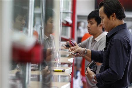 Customers show their ID cards before selling their items at Easy Money pawn shop in Bangkok, August 27, 2013. REUTERS/Athit Perawongmetha