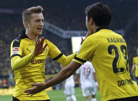 Borussia Dortmund's Marco Reus (L) and Shinji Kagawa of Japan celebrate a goal against FC Augsburg during their Bundesliga first division soccer match in Dortmund, Germany October 25, 2015. REUTERS/Ina Fassbender