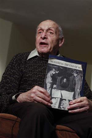 Harry Ettlinger holds a picture of himself while he speaks during an interview at his home at Rockaway in New Jersey, November 20, 2013. REUTERS/Eduardo Munoz