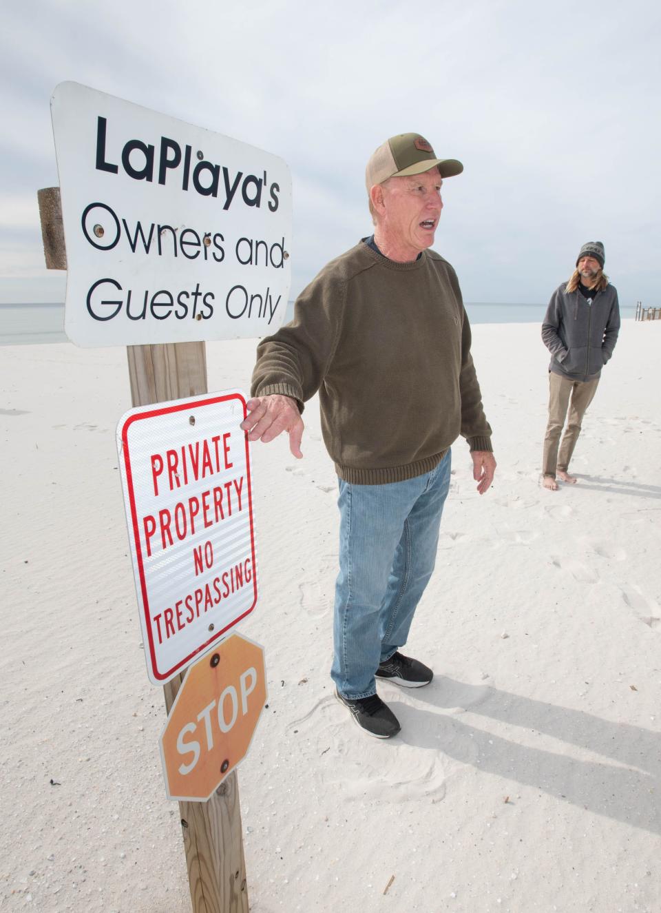 Gary Holt, left, explains why he and some other residents want the county to remove the "private property" and "no trespassing" signs dotting the sandy areas of the beaches on Perdido Key.