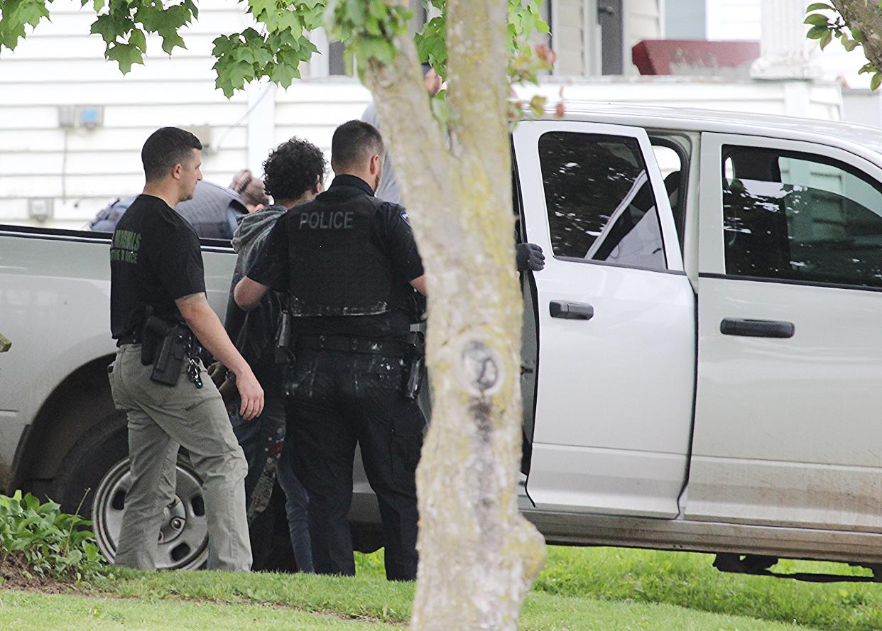 Officers from the US Marshals and the Ashland Police Department lead an arrested person into custody Tuesday.