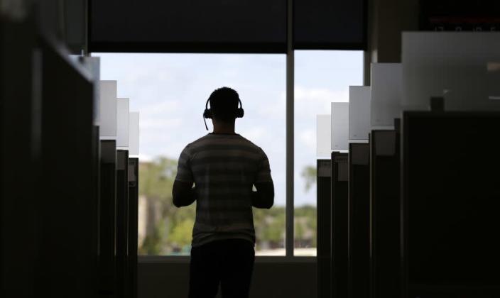 An advocate walks among cubicles at the National Domestic Violence Hotline center's new facility, Monday, June 27, 2016, in Austin, Texas. The center, which handles more that 1,000 calls, chats and texts per day, has doubled both its phone service stations and digital services stations. (AP Photo/Eric Gay)