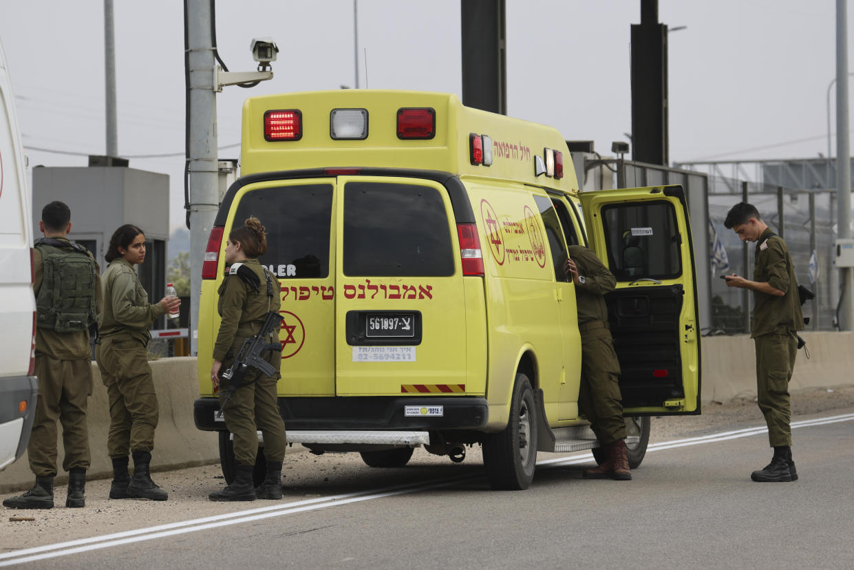 Israeli soldiers stand next to a military ambulance on a road leading to the site of stabbing attack, near the West Bank Jewish settlement of Elkana, Tuesday, Nov. 15, 2022. A Palestinian killed two Israelis and wounded four others in an attack in a settlement in the occupied West Bank on Tuesday before he was shot and killed by Israeli security personnel, Israeli paramedics and Palestinian officials said. (AP Photo/Oren Ziv)