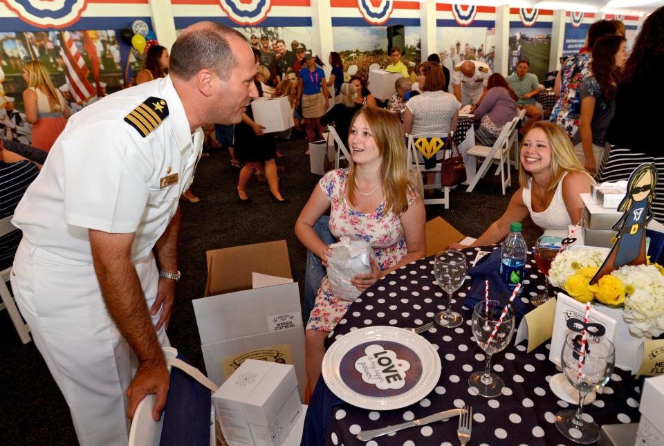 Capt. Howard Wanamaker, forrmer commanding officer at NAS Jacksonville, delivers shower gifts to Morgan Stephens and Natasha Bell during an Operation Shower the week before the 2016 Players Championship.