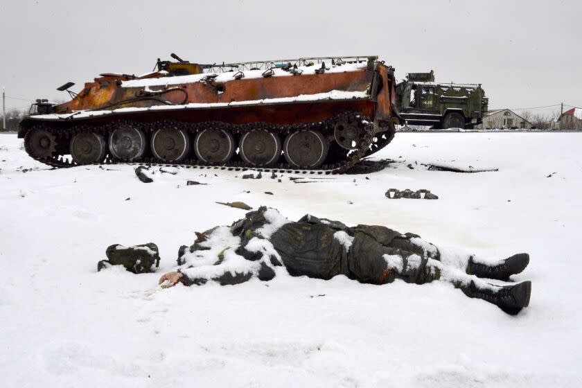 TOPSHOT - The body of a Russian serviceman lies near destroyed Russian military vehicles on the roadside on the outskirts of Kharkiv on February 26, 2022, following the Russian invasion of Ukraine. - Ukrainian forces repulsed a Russian attack on Kyiv but "sabotage groups" infiltrated the capital, officials said on February 26, as Ukraine reported 198 civilian deaths, including children, following Russia's invasion. A defiant Ukrainian President Volodymyr Zelensky vowed his pro-Western country would never give in to the Kremlin even as Russia said it had fired cruise missiles at military targets. (Photo by Sergey BOBOK / AFP) (Photo by SERGEY BOBOK/AFP via Getty Images)