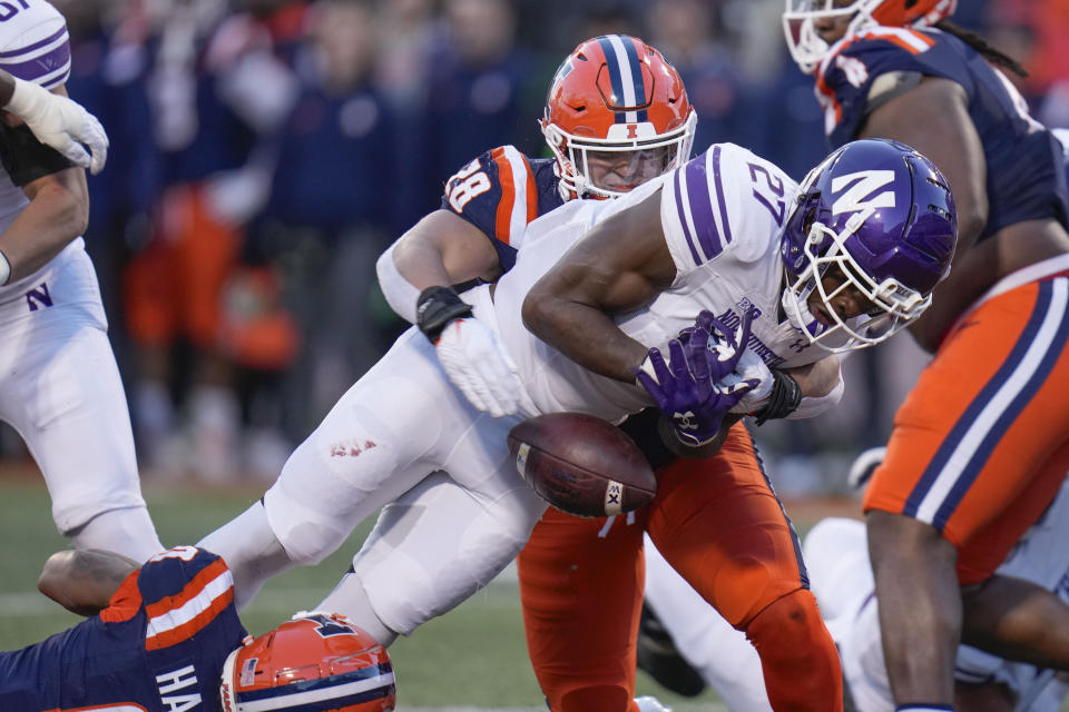 CORRECTS TO RUNNING BACK ANTHONY TYUS III NOT DEFENSIVE BACK JACK OYOLA - Northwestern running back Anthony Tyus III (27) fumbles during the first half of an NCAA college football game against Illinois, Saturday, Nov. 25, 2023, in Champaign, Ill. (AP Photo/Erin Hooley)
