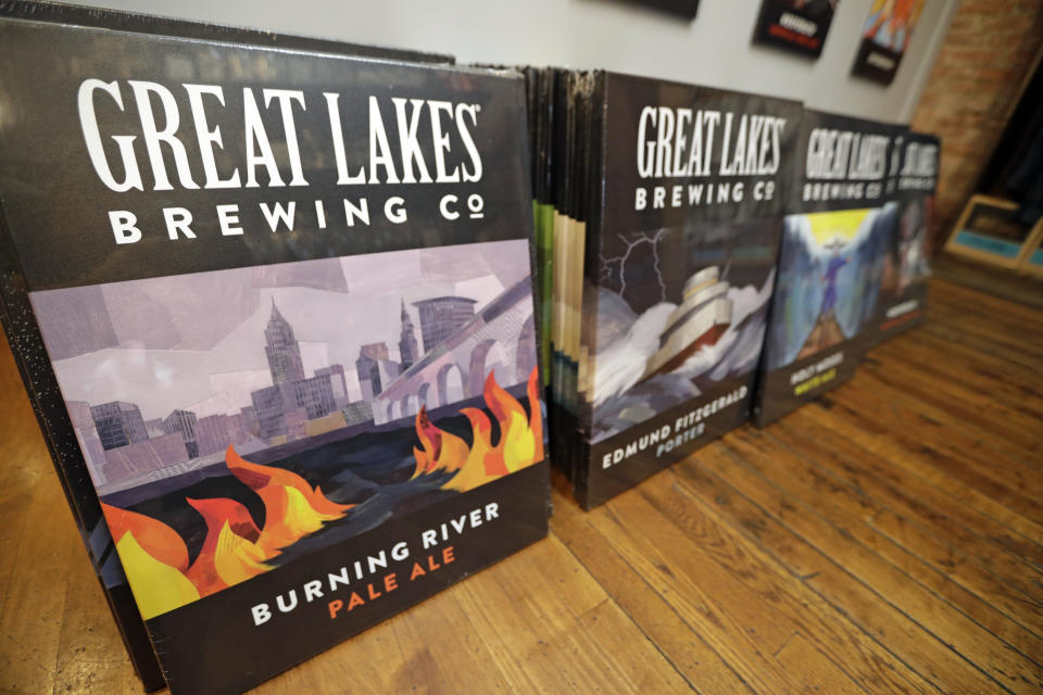 Posters are for sale featuring Burning River Pale Ale at the gift shop at the Great Lakes Brewing Company, Monday, June 17, 2019, in Cleveland. Fifty years after the Cuyahoga River's famous fire, a plucky new generation of Cleveland artists and entrepreneurs has turned the old jokes about the “mistake on the lake” into inspiration and forged the decades of embarrassment into a fiery brand of local pride. (AP Photo/Tony Dejak)