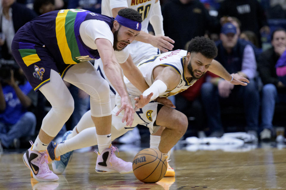 New Orleans Pelicans forward Larry Nance Jr. (22) and Denver Nuggets guard Jamal Murray (27) reach for the ball during the second half of an NBA basketball game in New Orleans, Tuesday, Jan. 24, 2023. (AP Photo/Matthew Hinton)