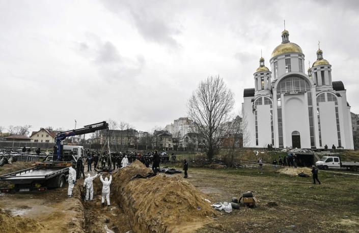 Ukrainian investigators exhume bodies from a mass grave in Bucha, Ukraine, in April 2022. <a href="https://media.gettyimages.com/id/1239836657/photo/topshot-ukraine-russia-conflict.jpg?s=1024x1024&w=gi&k=20&c=c4Da9Wl_2bWRs0_4eyieSucGBaSoBm6Ro27U82ZKtw8=" rel="nofollow noopener" target="_blank" data-ylk="slk:Genya Savilov/AFP via Getty Images;elm:context_link;itc:0" class="link ">Genya Savilov/AFP via Getty Images</a>