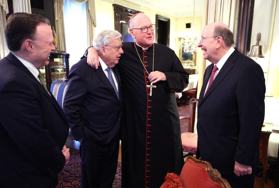 Cardinal Timothy M. Dolan laughs with, from left,  Elder David L. Buckner, President M. Russell Ballard and Elder Quentin L. Cook.