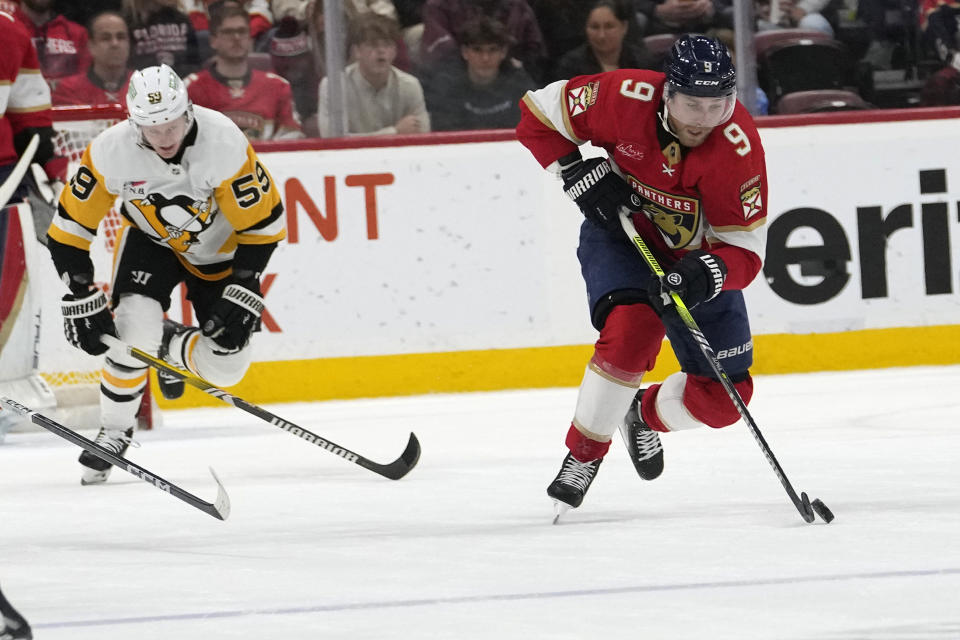 Florida Panthers center Sam Bennett (9) skates with the puck as Pittsburgh Penguins left wing Jake Guentzel (59) defends during the second period of an NHL hockey game, Friday, Dec. 8, 2023, in Sunrise, Fla. (AP Photo/Lynne Sladky)