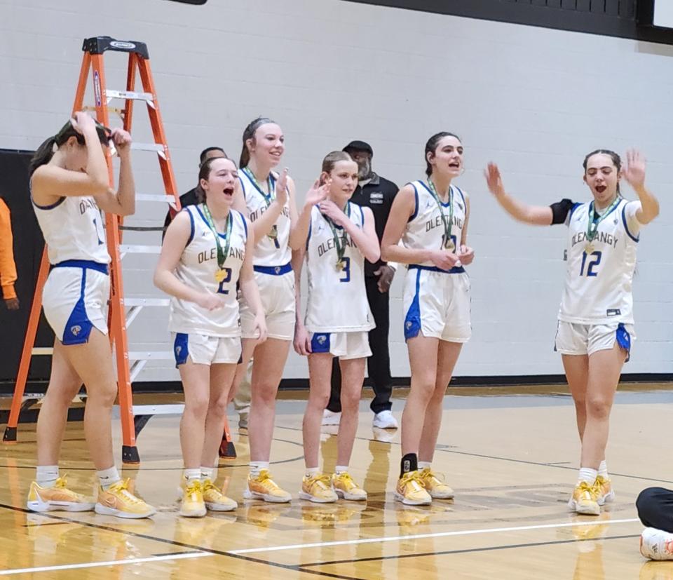 Olentangy players, from left, Meryl Kolath, Morgan Billiter, Brianna Carberry, Mia Kirtley and Whitney Stafford celebrate winning the Division I district championship trophy Saturday at Ohio Dominican. The Braves defeated Upper Arlington 57-40 for their first district title since 1998.