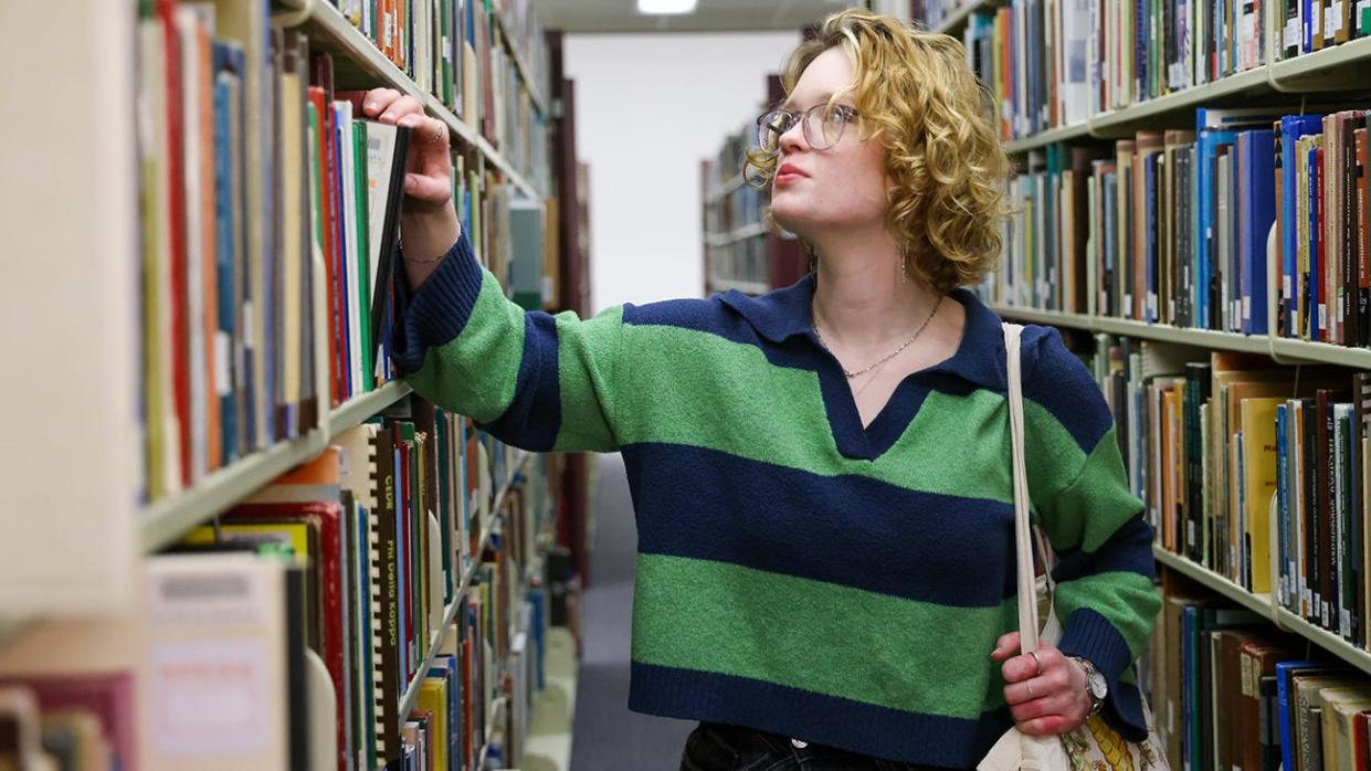 Charlotte Plotts, the 2023 valedictorian of Canyon High School, peruses books in West Texas A&M University's Cornette Library. Though she was accepted at larger schools, Charlotte found a welcoming home at WT.